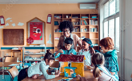 Teacher and diverse students engaged in a craft project in classroom photo