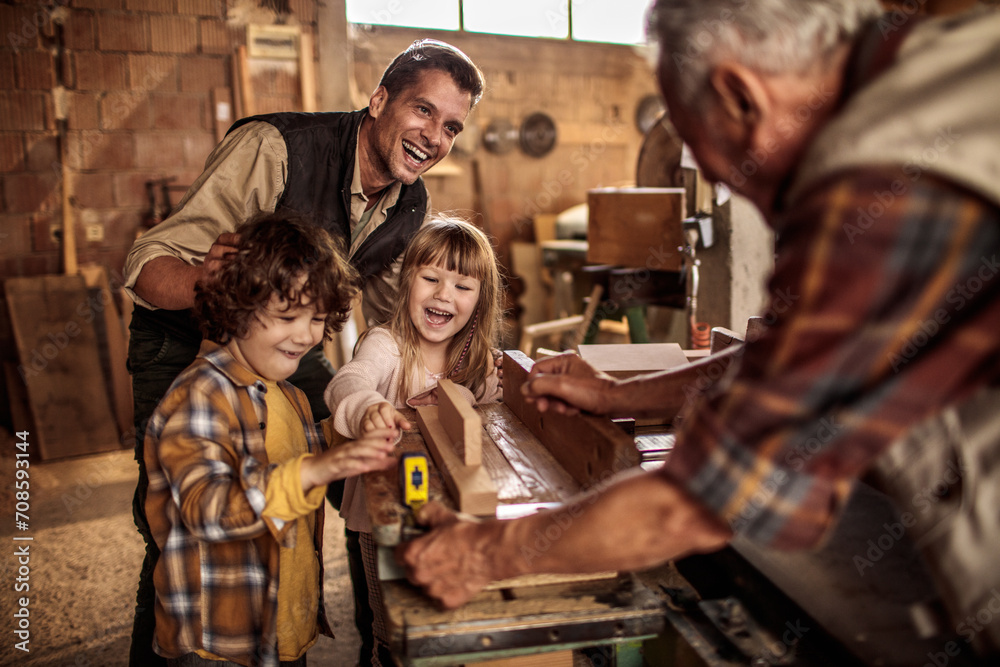 Happy family woodworking together in a workshop