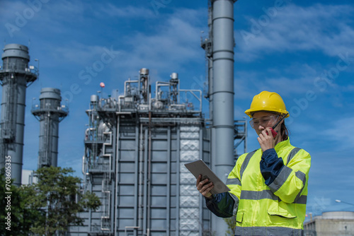 worker with helmet. Worker woman hand hold tablet working with power plant on background. Portrait engineer working on power plant.