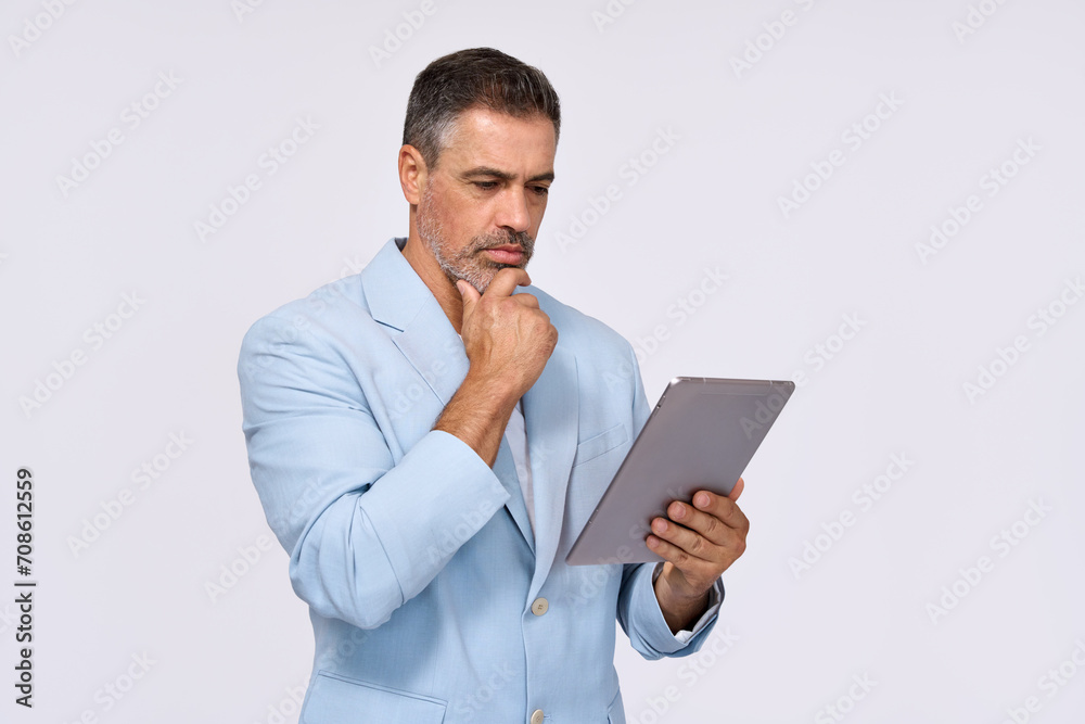 Busy middle aged business man ceo wearing suit standing isolated on white using digital tablet. Older businessman professional executive manager looking at pad thinking working on tab device. Busy middle aged business man ceo wearing suit standing isolated on white using digital tablet. Older businessman professional executive manager looking at pad thinking working on tab device.