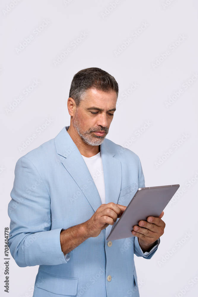 Busy middle aged business man ceo wearing suit standing isolated on white using digital tablet. Older businessman professional executive manager looking at pad working on tab device. Vertical Busy middle aged business man ceo wearing suit standing isolated on white using digital tablet. Older businessman professional executive manager looking at pad working on tab device. Vertical