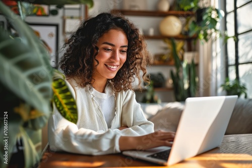 Young happy latin woman, smiling curly casual girl student using tablet and laptop elearning or hybrid working at home online looking at tab device sitting at table in living room, Generative AI photo