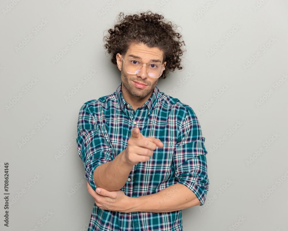 casual young guy with glasses pointing fingers forward and smiling - obrazy, fototapety, plakaty 