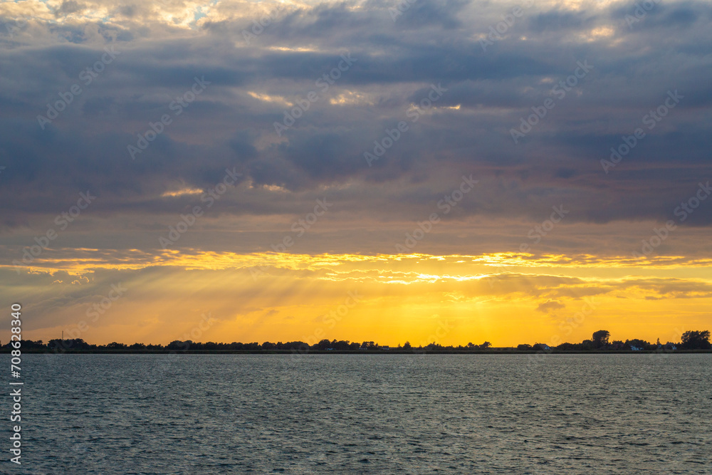 Sonnenuntergang an der Ostsee, Sonnenstrahlen durch bewölkten Himmel Sonnenuntergang an der Ostsee, Sonnenstrahlen durch bewölkten Himmel