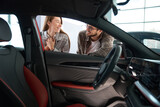 Woman and man choosing car dreaming to buy or rent automobile