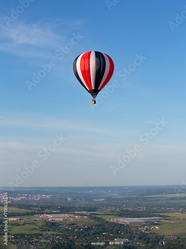 Colorful hot air balloon against the blue sky. Balloon flight. Summer morning.