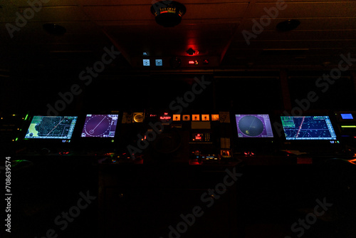 Navigational bridge on big cargo ship. Wheelhouse on vessel. ECDIS, radar. Night time. photo