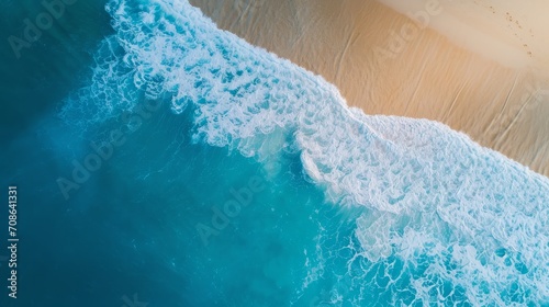 Aerial beach view with vibrant blue waves crashing onto golden sands. Perfect for travel and nature themes.