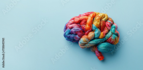 Human brain made of multi-colored tangled threads on blue background, banner with copy space, concept of neurodiversity and mental problems photo