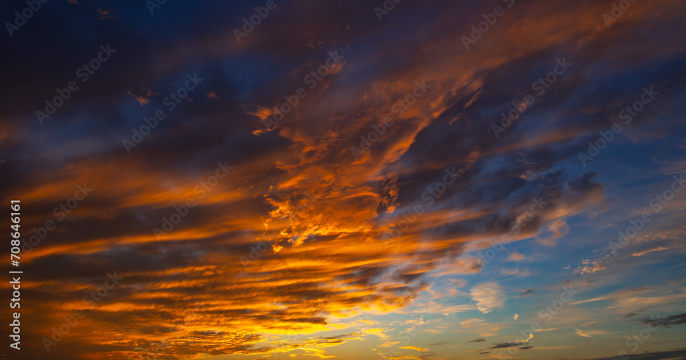 Sunset or sunrise. Dramatic majestic scenery sunset. Sky with clouds in sunset sky light background. Sunrise with clouds in various shapes. Calm sunset sky and sun through clouds over.