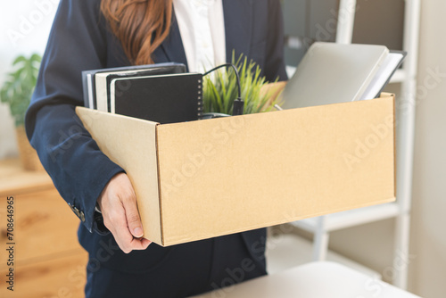 Unemployment, quitting job concept, desperate asian young business woman resigning or fired, leave from company, female holding belongings, stuff into box cardboard, layoff or leaving, changing work.