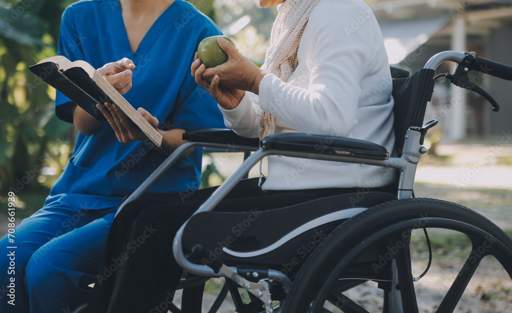 Obraz premium A nurse take care a senior male on wheelchair in his garden at home