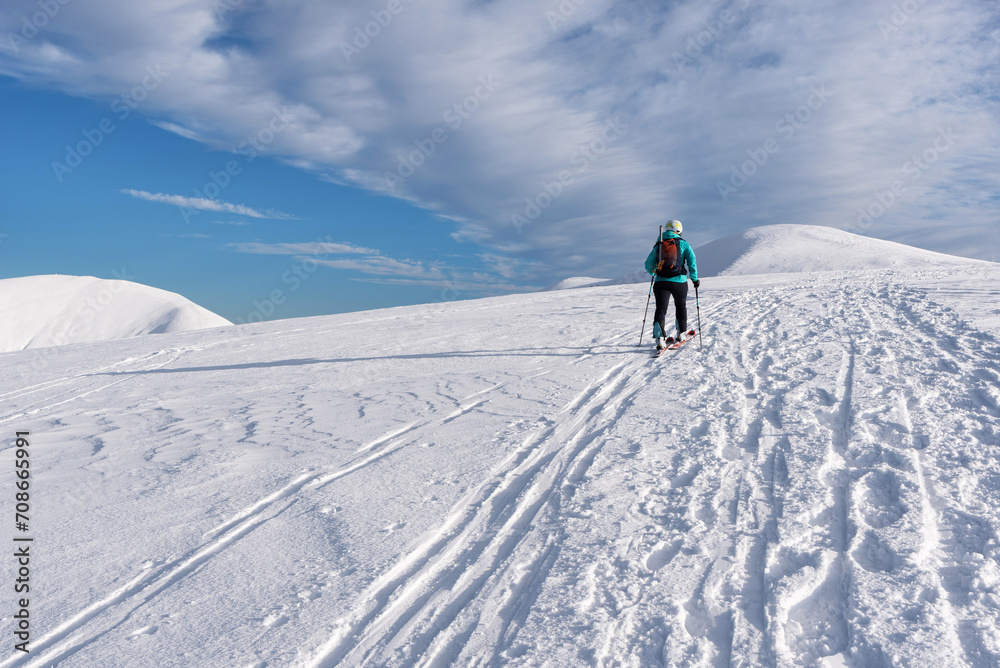 Skier woman climbs the snowy hill. ski touring