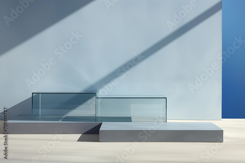 Product podium, two transparent glass displays on a sleek, gray platform with dynamic shadows, against a two-tone blue wall backdrop