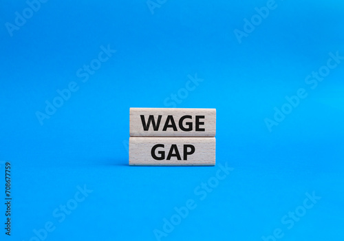 Wage Gap symbol. Concept words Wage Gap on wooden blocks. Beautiful blue background. Business and Wage Gap concept. Copy space.