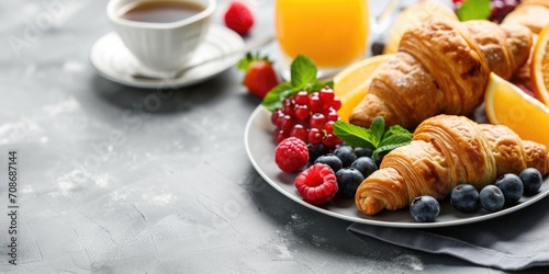 A delicious plate of fresh fruit and warm croissants served with a steaming cup of coffee. Perfect for a refreshing and energizing breakfast.