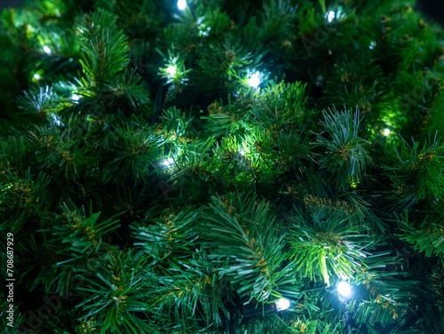 Close-up branches of Christmas tree made of garland shimmers with LED lights