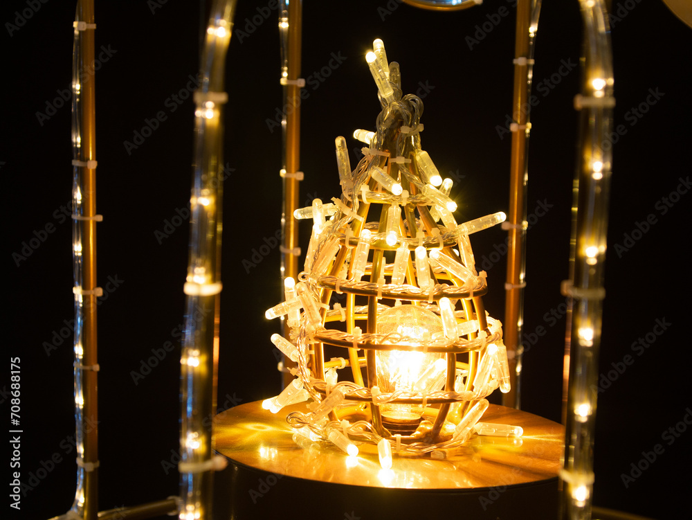 Decorative glowing yellow lantern from an LED garland on black background Decorative glowing yellow lantern from an LED garland on black background