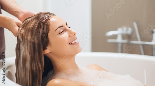 Pleasured young woman enjoys head massage taking foamy bath in cosmetology salon
