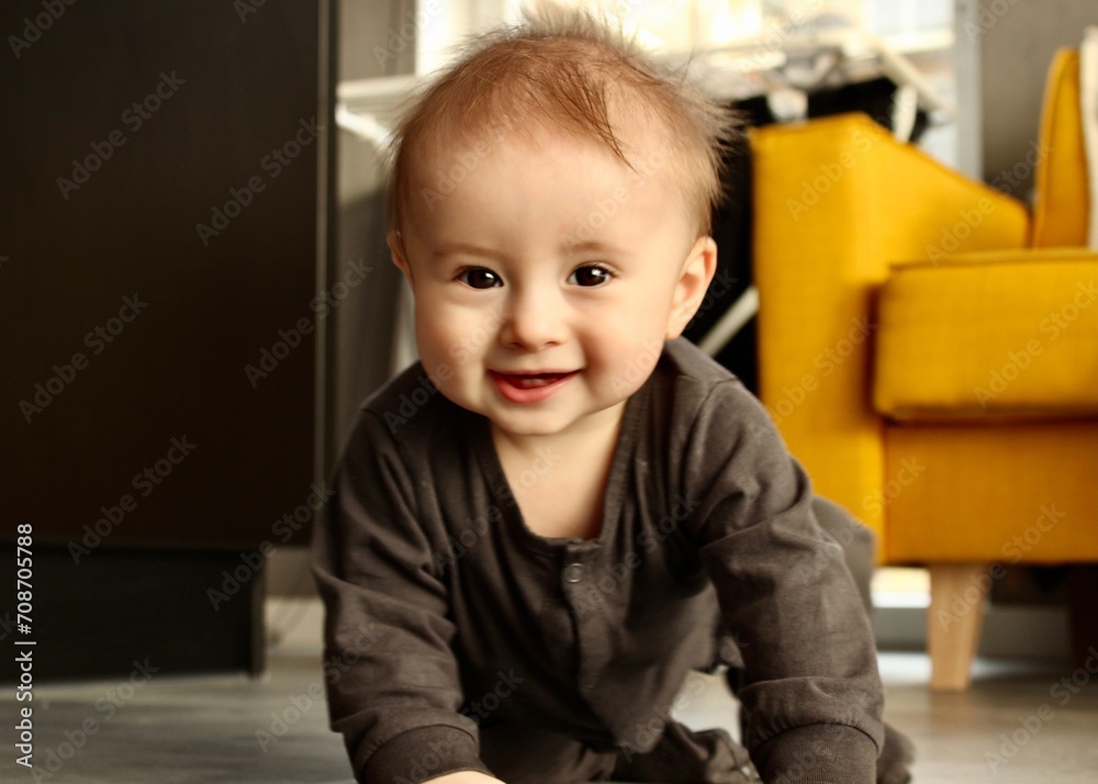 A toddler boy crawls forward looking at the camera and laughs A toddler boy crawls forward looking at the camera and laughs