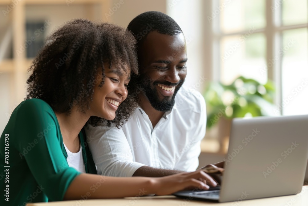 Dressed professionally, a couple shares smiles while engaged with a laptop screen, fostering a warm atmosphere in a home office, exchanging joyful information Dressed professionally, a couple shares smiles while engaged with a laptop screen, fostering a warm atmosphere in a home office, exchanging joyful information