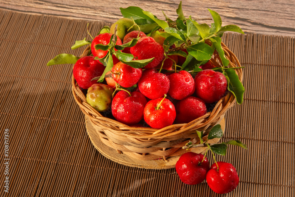 Freshly Harvested Organic Acerolas in a Basket on a Wooden Textured Table Freshly Harvested Organic Acerolas in a Basket on a Wooden Textured Table