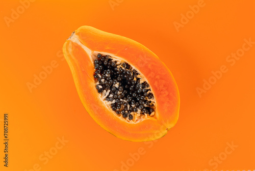 Papaya fruit on orange, yellow background. Half of fresh organic Papaya exotic fruit close up. Top view 