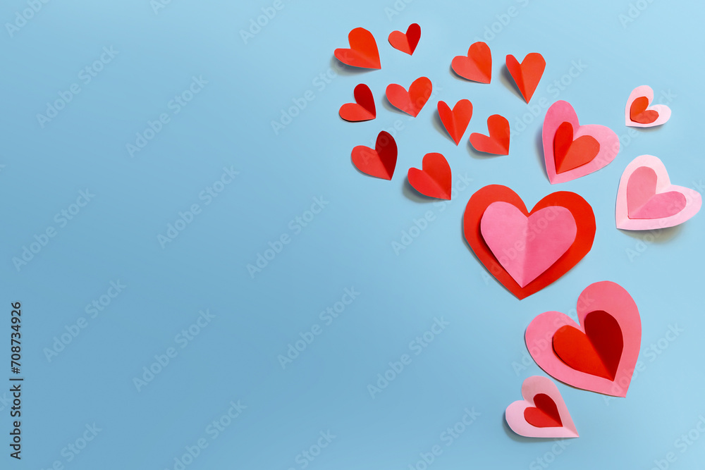 Beautiful paper hearts arranged on a sky-blue background. Greeting card concept for Valentine's Day. Mother's Day. copyspace