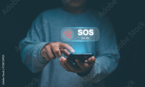 Emergency signal requesting help call concept. Human hand touching icon SOS emergency app on mobile phone and call for help. Emergency application from smartphone for elderly, 24 hour support line.
