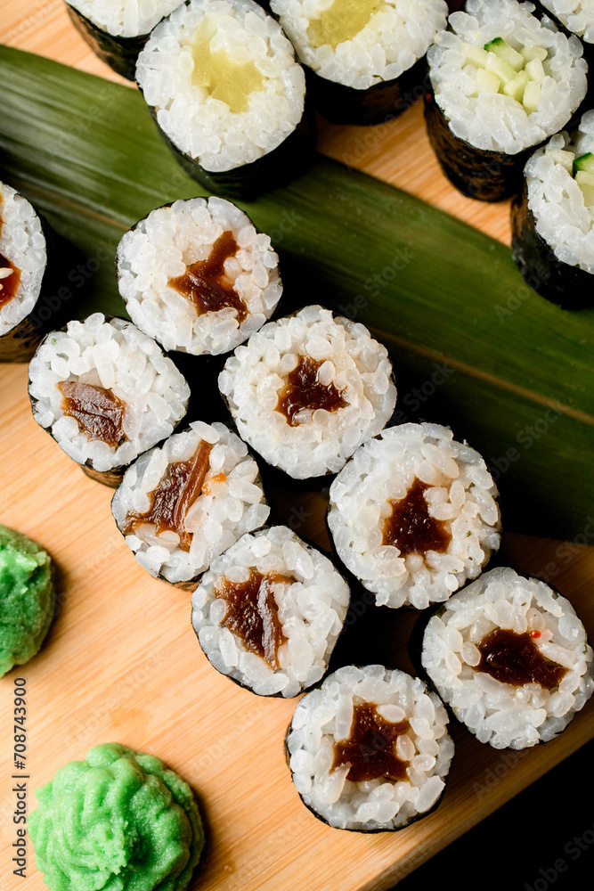 Portion of sushi with eel on a wooden board Portion of sushi with eel on a wooden board