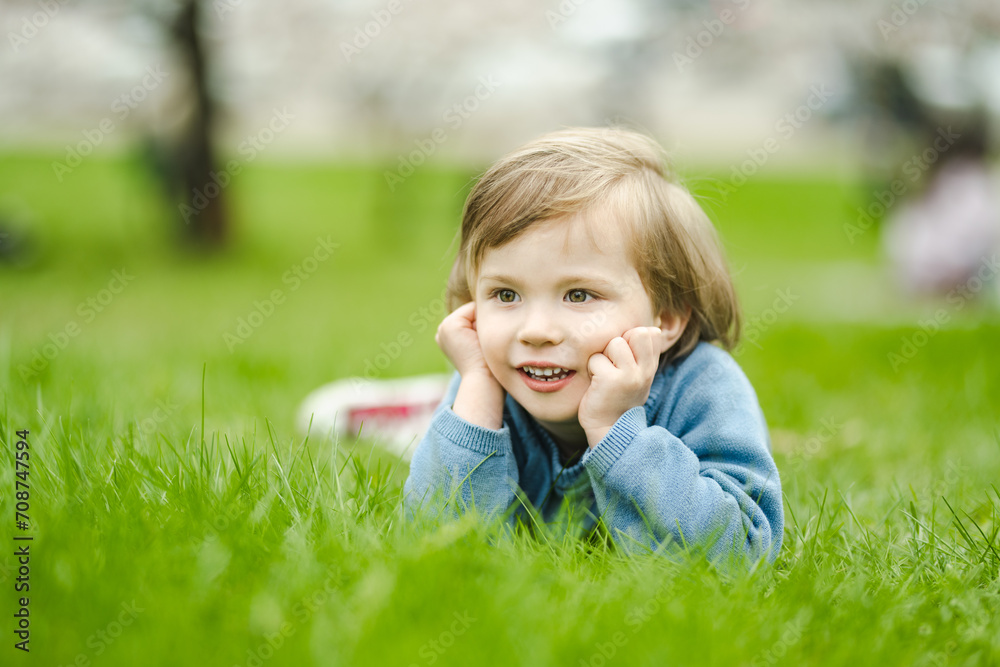 Cute toddler boy playing in blooming cherry tree garden on beautiful spring day. Adorable baby having fun outdoors. Cute toddler boy playing in blooming cherry tree garden on beautiful spring day. Adorable baby having fun outdoors.