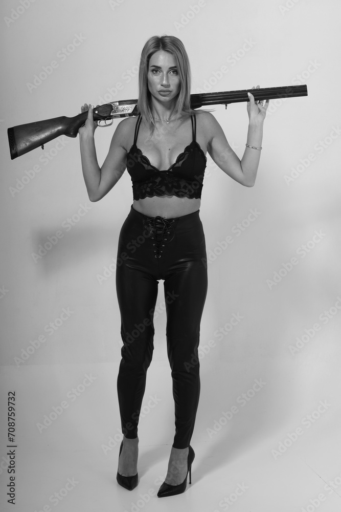 Pretty slender woman in lingerie holding old shotgun in black and white Pretty slender woman in lingerie holding old shotgun in black and white