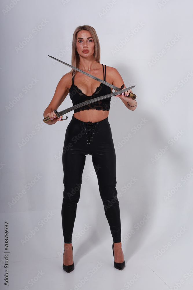 Pretty blonde woman in black lingerie holding two old swords crossed Pretty blonde woman in black lingerie holding two old swords crossed
