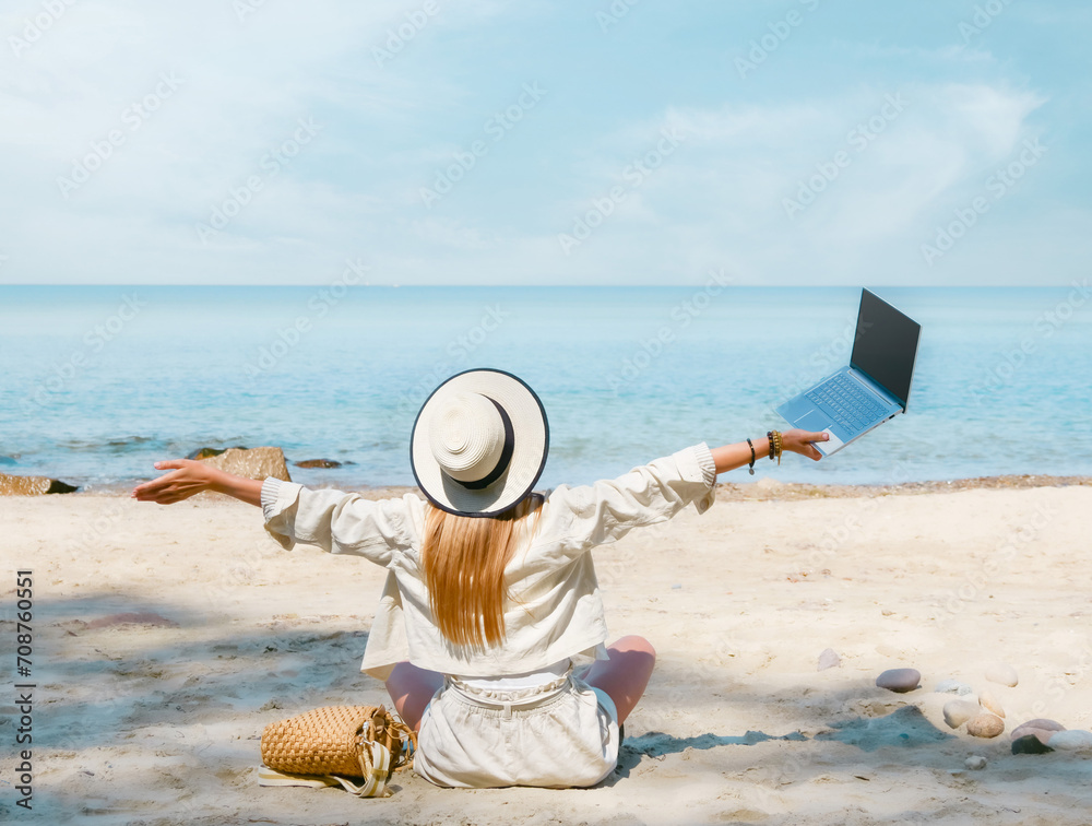 young woman uses laptop computer on the beach. distance work, freelancer and blogger concept. WiFi unlimited