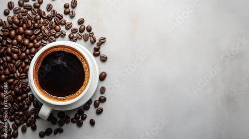 Cup of black coffee surrounded by roasted coffee beans on a light textured surface with copy space