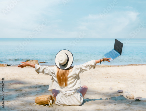 Obraz na płótnie young woman uses laptop computer on the beach. distance work, freelancer and blogger concept. WiFi unlimited w salonie