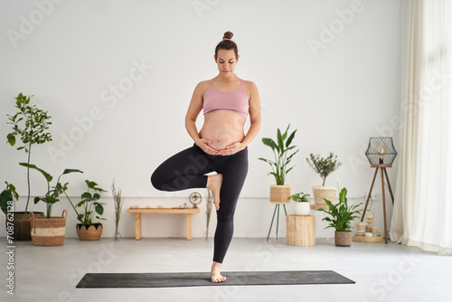Valokuva Future mom pregnant Caucasian woman in sportswear doing yoga pose indoors