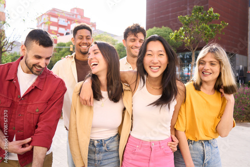 Generation z people walk carefree and cheerful. Group smiling multiracial friends having fun outdoors. Joyful young student laughing together on vacation. Community, youth lifestyle and friendship