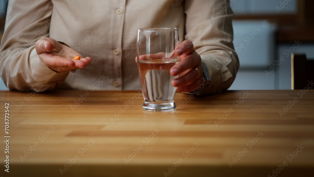 Young woman taking her medicine while sitting in the kitchen
Young woman taking her medicine while sitting in the kitchen