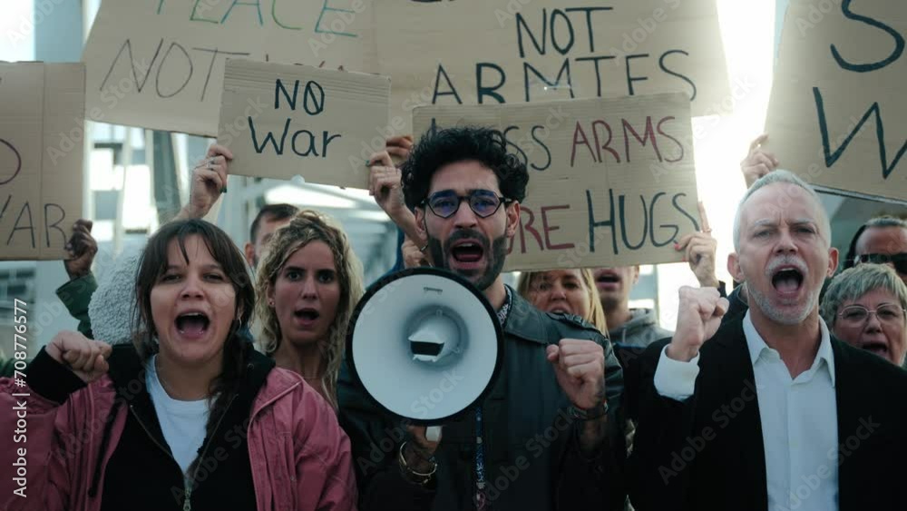 Multiracial and diverse ages people protesting against war and violence in the world looking at camera. Group of activists with anti-war banners at a demonstration for peace and human rights. 