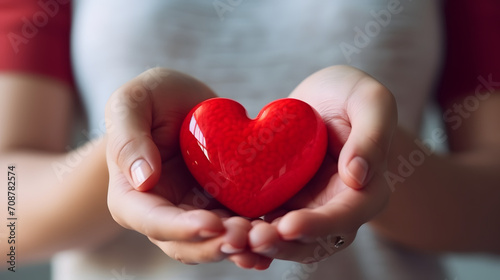 a young woman person holds small red heart candy in her hands.