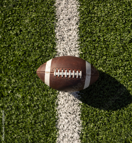 Top down view of an American Football resting on the goal line at a football stadium. Generic American Football photo. View from above looking down at the laces of a ball