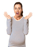 Pregnant middle-aged woman in studio setting surprised and shocked.