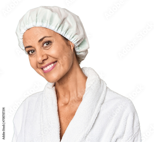 Middle-aged woman in bathrobe with shower cap in studio