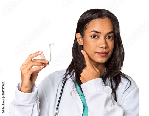 Young Filipina doctor holding hearing amplifier in studio