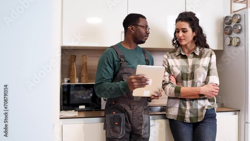 Woman talking with a handyman about the work at her kitchen photo