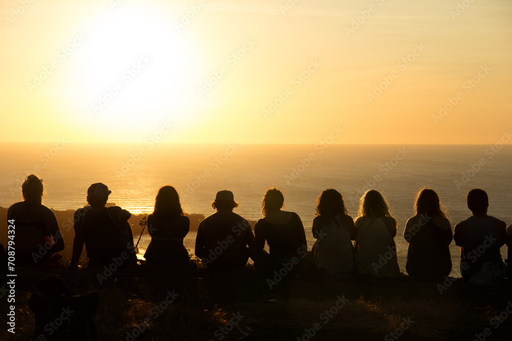 Obraz premium Group of people watching a sunset from a mountain 
