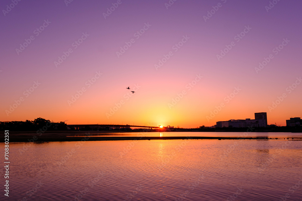 夜明け前の海岸。オレンジ色に染まる空。兵庫県西宮市の香櫨園浜で撮影