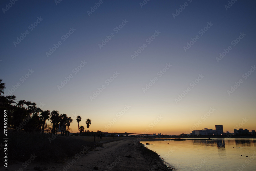 夜明け前の海岸。オレンジ色に染まる空。兵庫県西宮市の香櫨園浜で撮影
