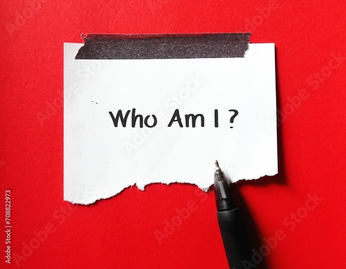 Stick note on red background with handwriting Who Am I? - concept of self-discovery - finding your sense of self or discover your true self